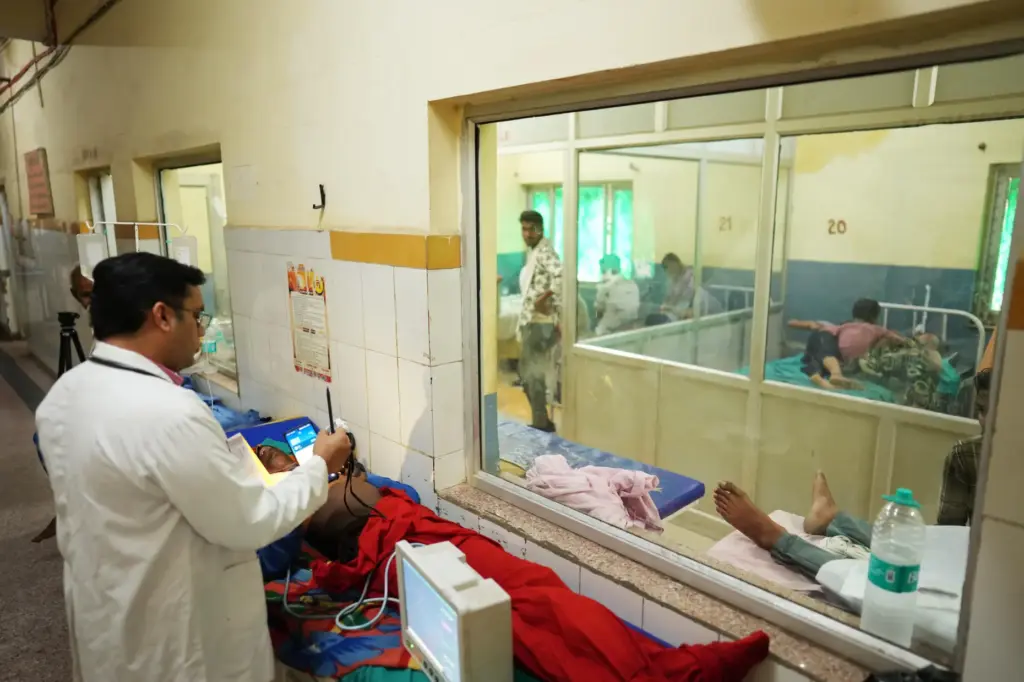 FILE – Dr. Abhishek Pranayami examines a patient suffering from...