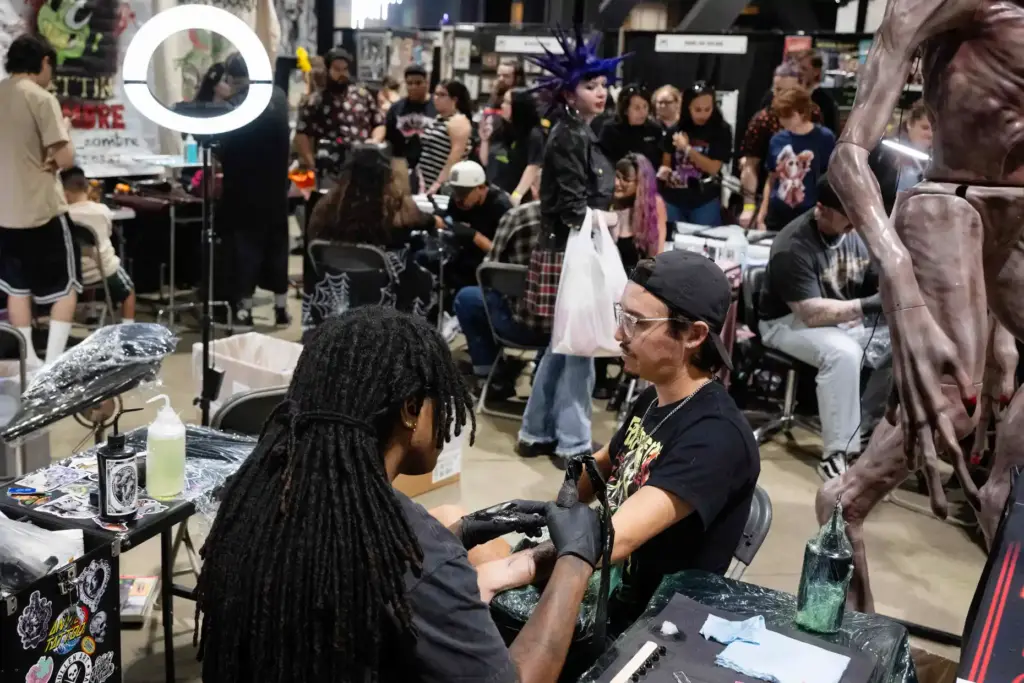 From left, Goldie Johnson tattoos a Freddy Krueger rose on...