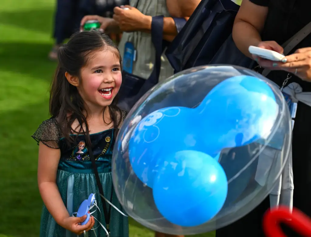 Piper Johnson, 3, plays with a balloon during Disneyâs âHappiest...