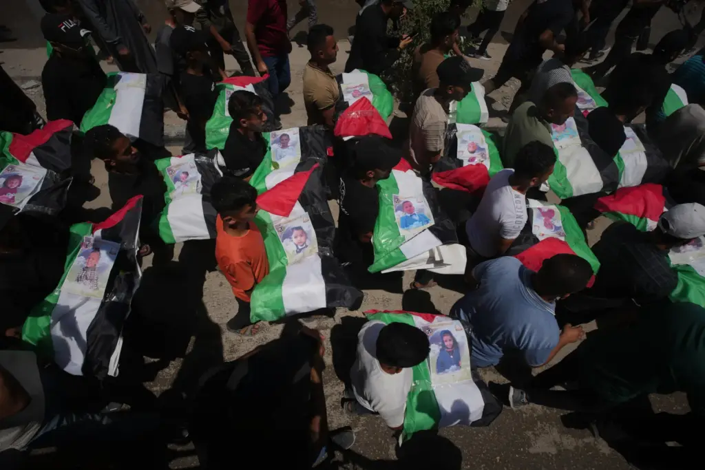 Palestinians carry the flag-draped bodies of members of the Hassayna...