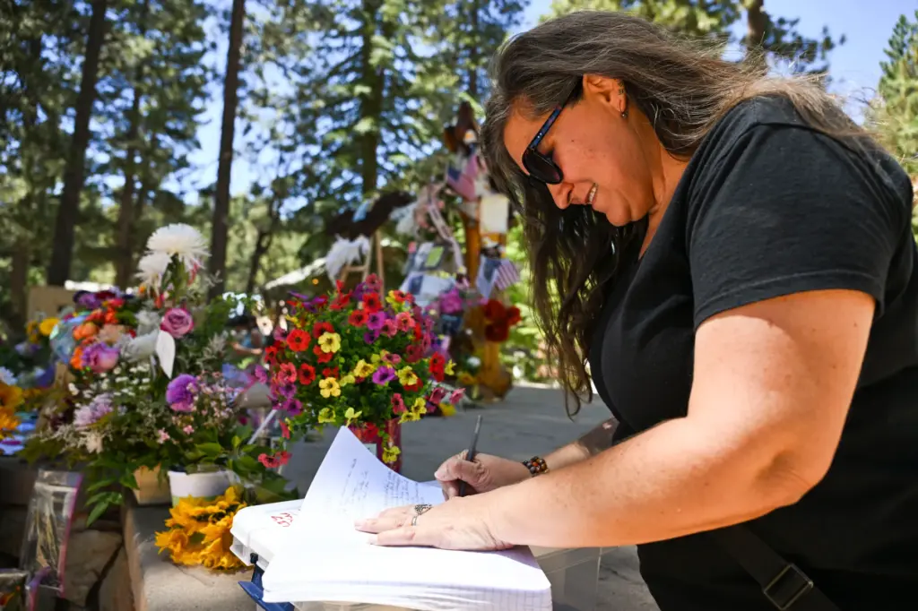 Dawn Manginen-Glenn leaves a note in the guestbook at the...