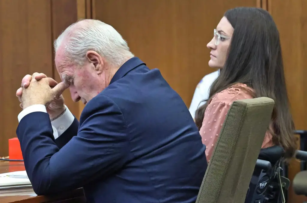 Defense attorney Kevin Reddington, seated with client Lindsay Clancy, listens...