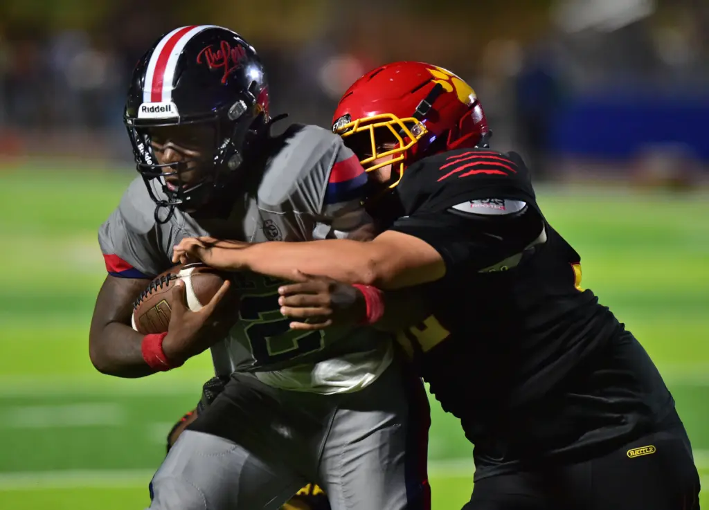 Leuzinger back Milton Jefferson is stopped by Hawthorne’s Ricardo Robinson...