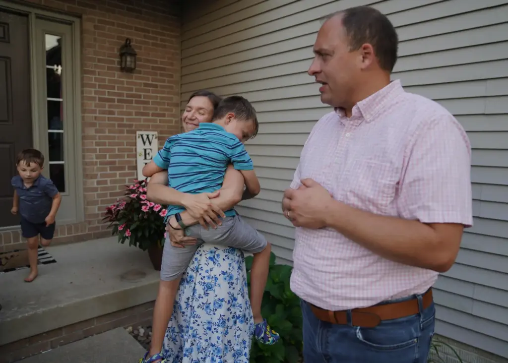 Lizzy Taggart holds her son Fulton, 8, while standing with her husband, Joe.