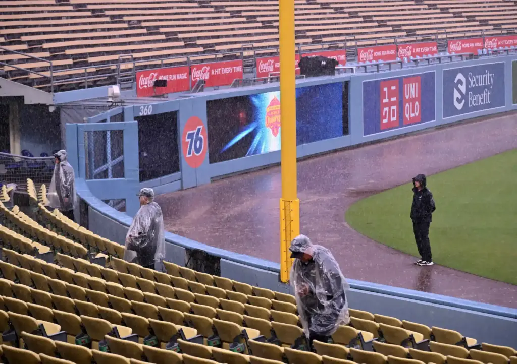 Dodgers security officers stand in the rain before the game...