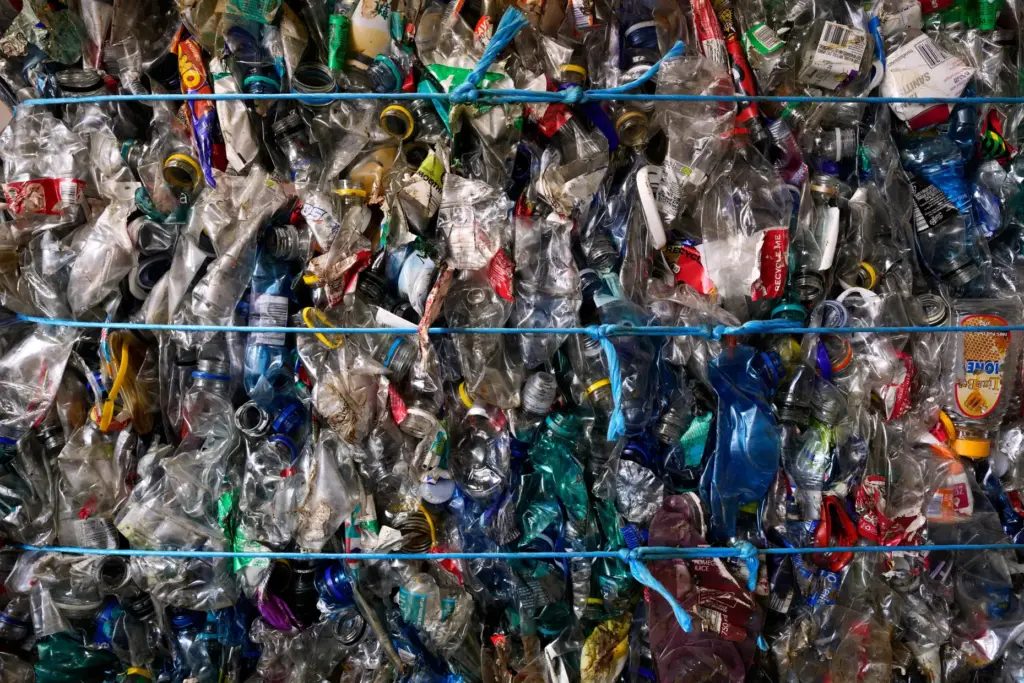 Bales of compressed plastic bottles ready for recycling are displayed...