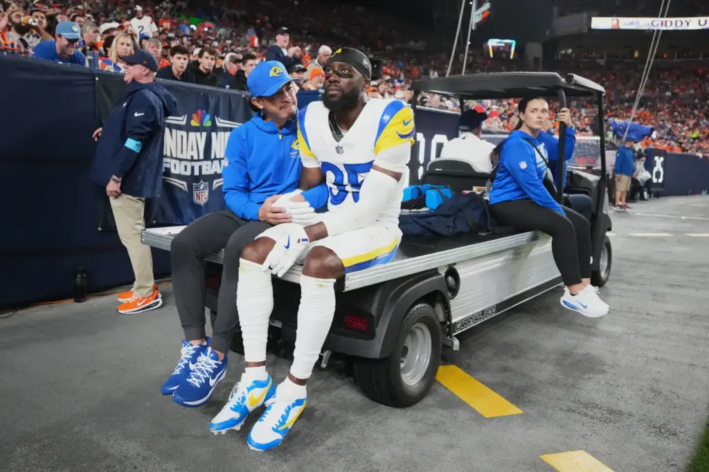 Rams cornerback Jaylen Watson leaves the field on a cart...