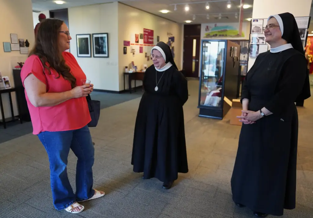 Bonnie Engstrom talks with two sisters at the Archbishop Fulton Sheen Museum.
