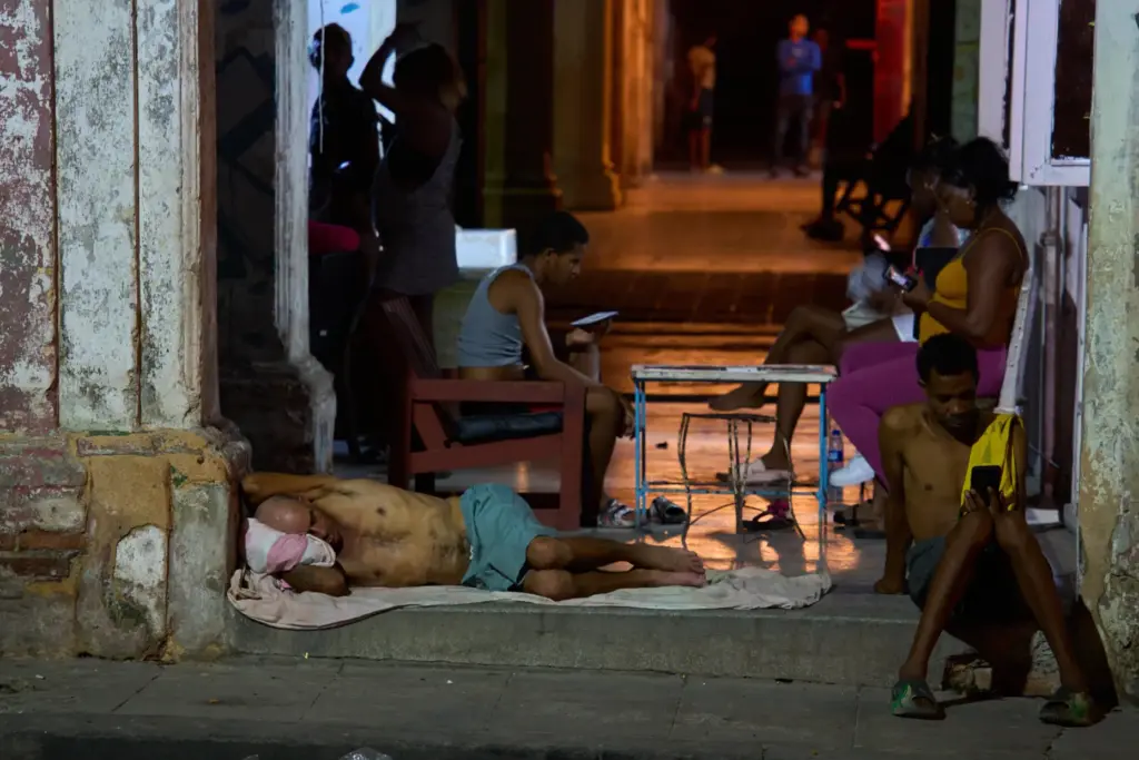 A man sleeps in the doorway of his home while...