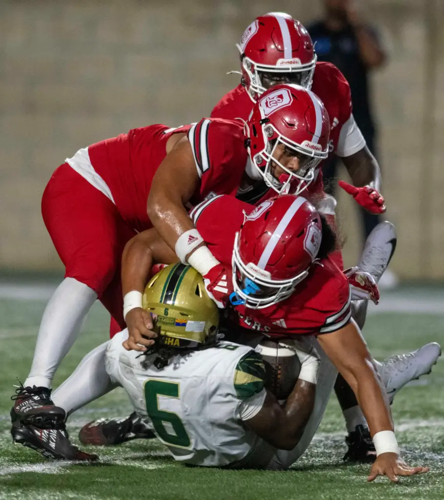 Orange Lutheranâs defense swarms Bashaâs Noah Roberts (6) during a...