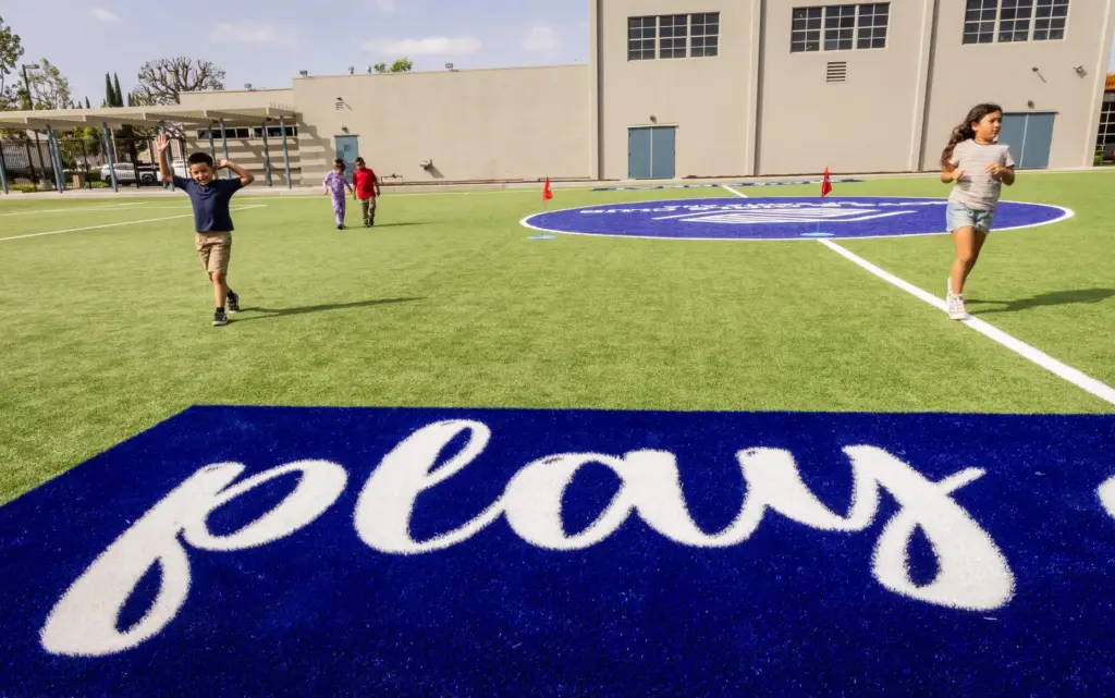 Children run across the new field at the recently opened...