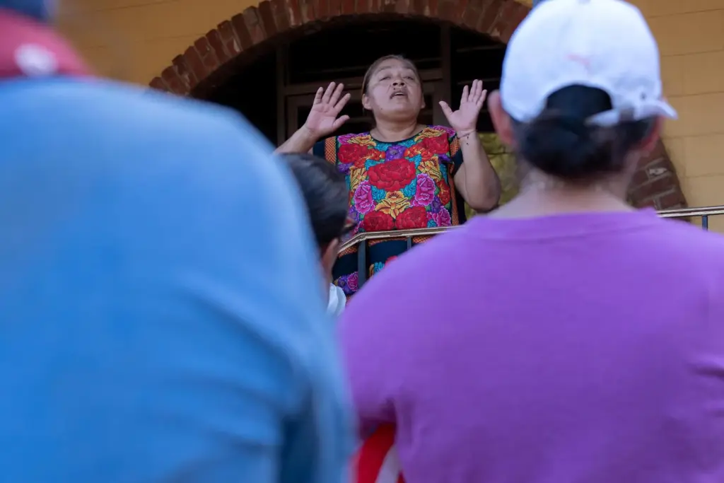 Norma Gómez speaks to a crowd at a monthly food...