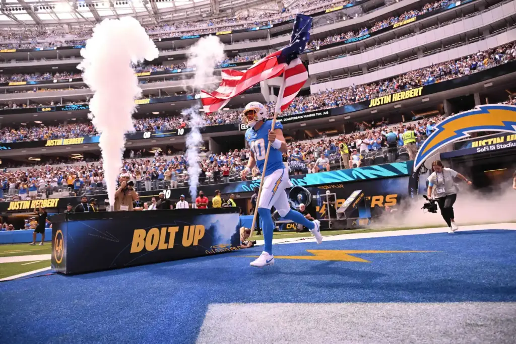 Chargers quarterback Justin Herbert (10) enters the field carrying the...
