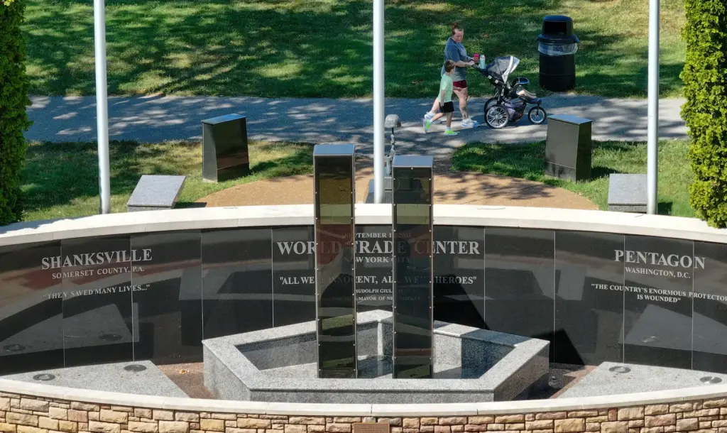 People walk past the Heroes Memorial at Fenton City Park...