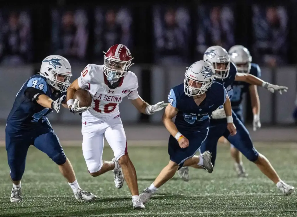 La Serna wide receiver Landon Armenta (10) carries the ball...