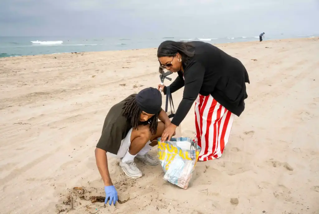 David Dubon digs through sand while his mother, Karlen, looks...