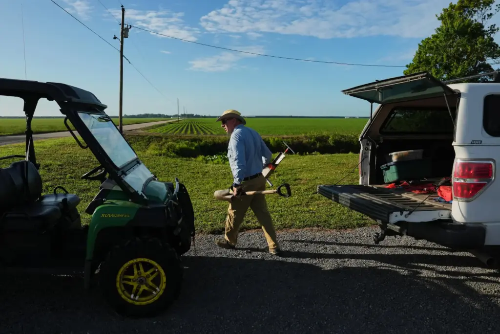 Neal Flanagan, a research scientist at Duke University, carries soil...