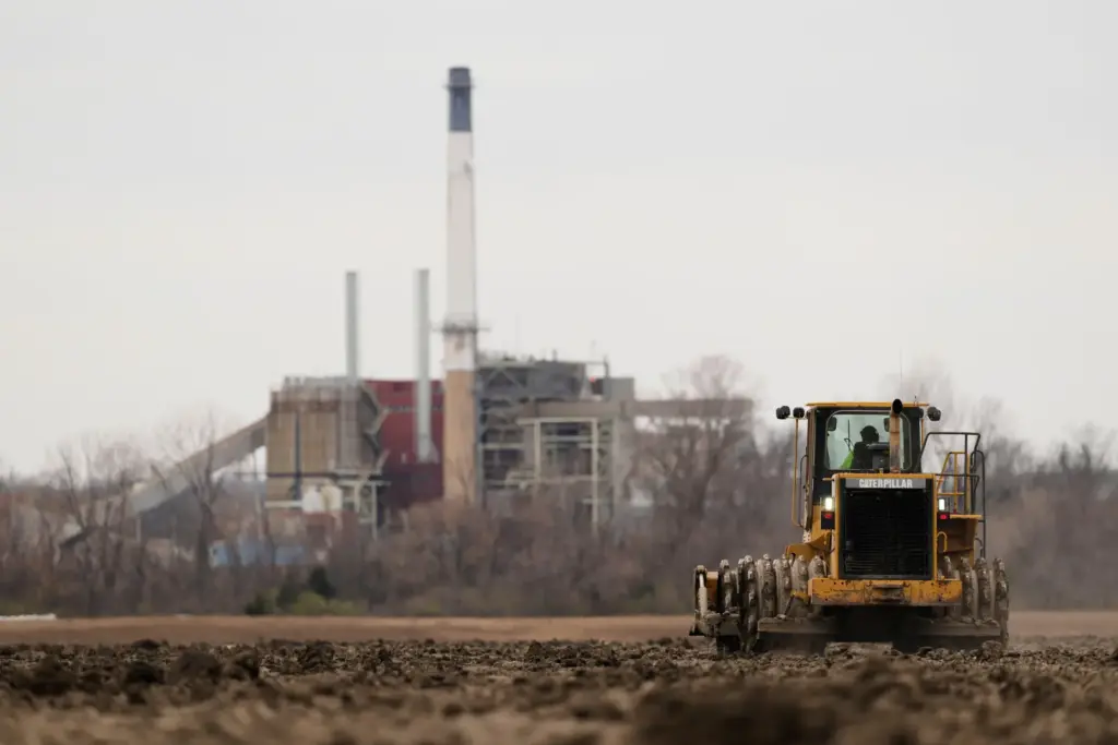 A worker prepares a plot of land for an AI data center.