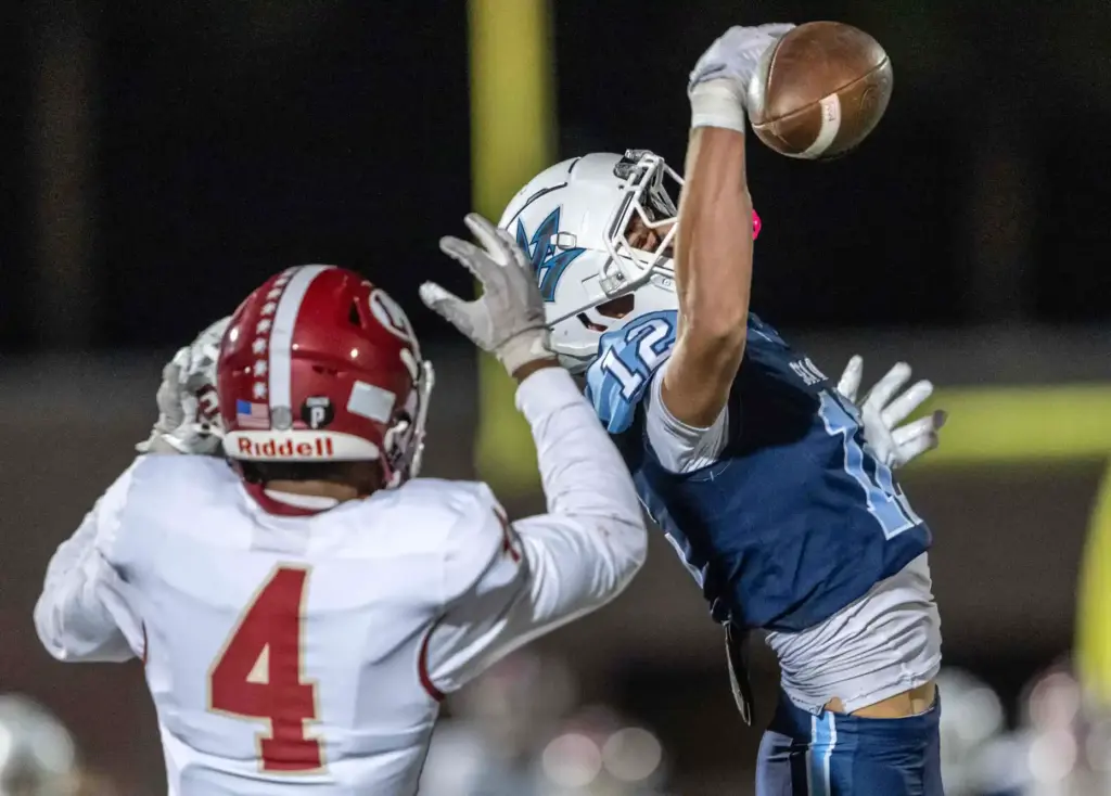 Corona del Mar defensive back Nate Rothman (12), right, breaks...