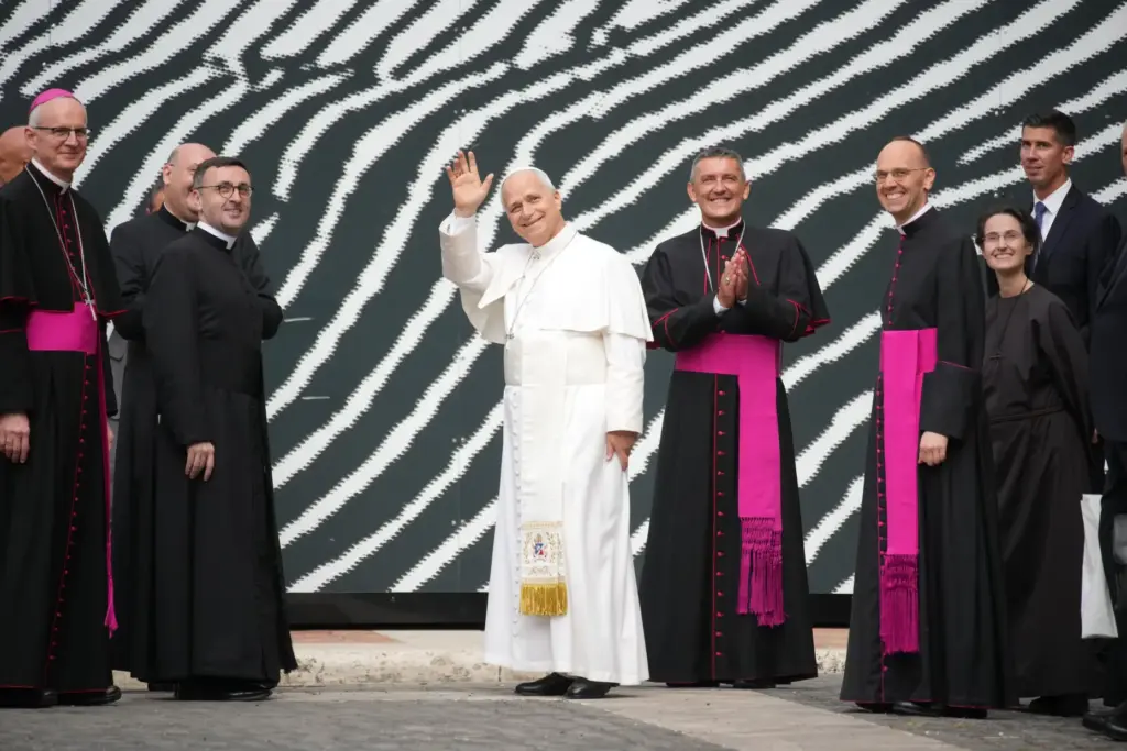 Pope Leo XIV waves as he arrives with Bishop Giacomo Cardinali and Raffaella Petrini.