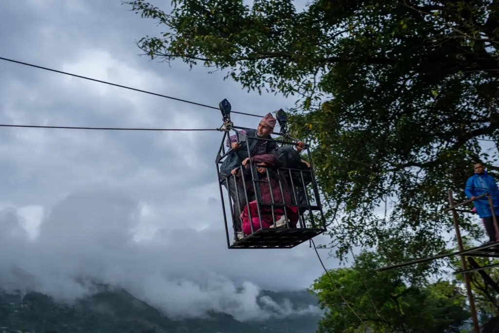 Residents commute across the Trishuli river on a newly installed...
