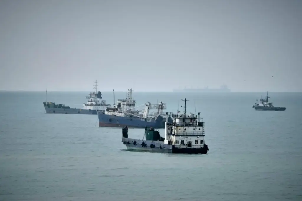 Commercial vessels lie anchored in the Strait of Hormuz off Bandar Abbas, Iran.