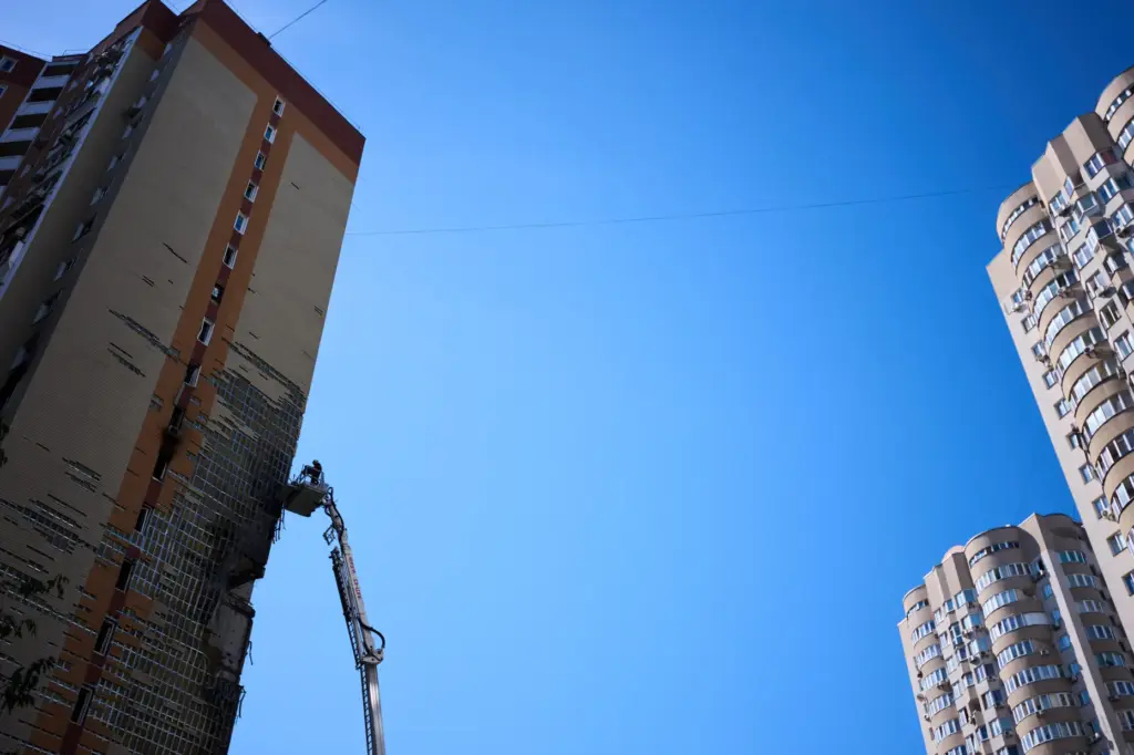 Firefighters work on a partially damaged residential building following a Russian drone attack in Kyiv.