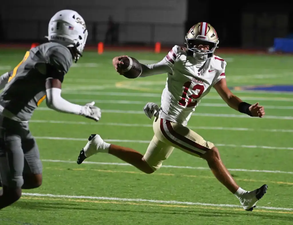 JSerraâs quarterback Jack Hilgenberg (12) runs with the ball as...