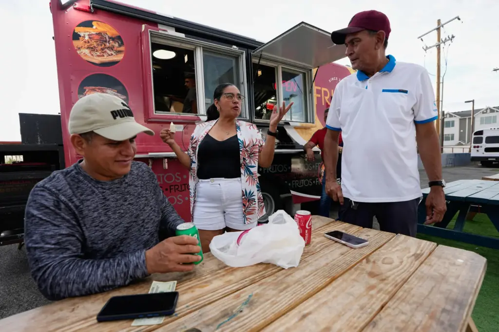 Venezuelans gather outside a food truck on Wednesday, July 15,...