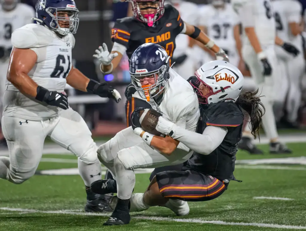Trabuco Hills running back Luke Hoffman, left, is wrapped up...