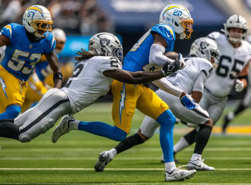 Chargers cornerback Cam Hart (20) carries the ball after making...