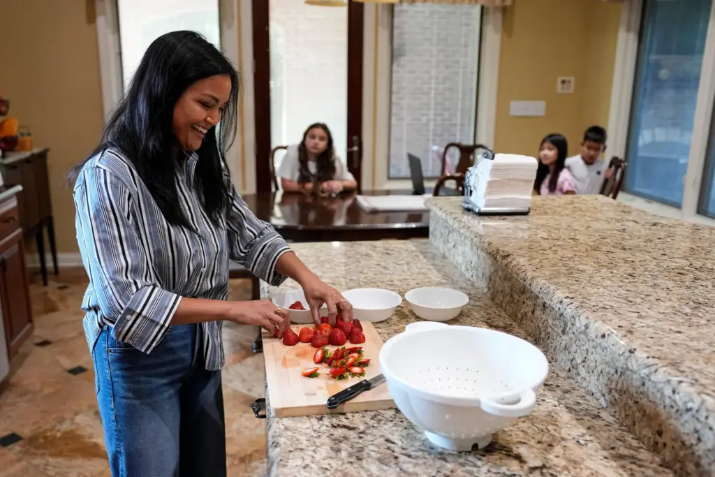 Monette Wagner cuts strawberries as she prepares an after-school snack...