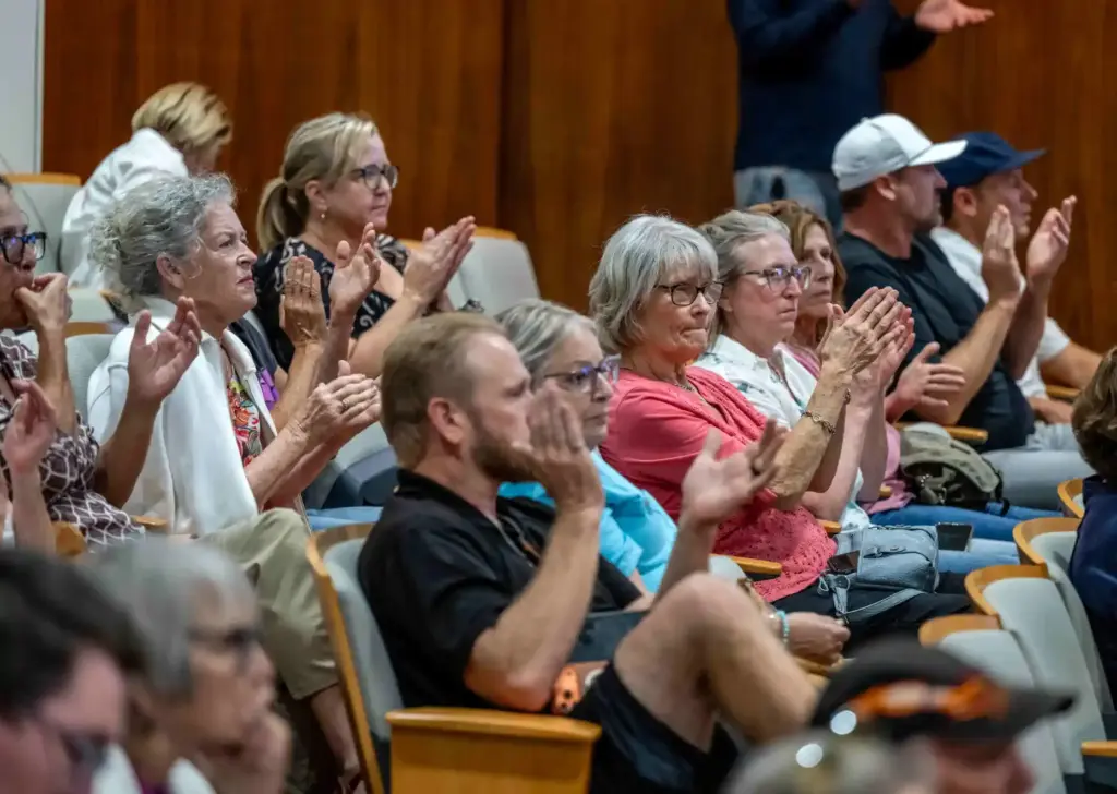 Costa Mesa residents applaud as a fellow resident argues that...
