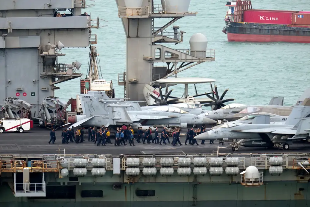Navy personnel walk on the deck of the USS Abraham Lincoln.