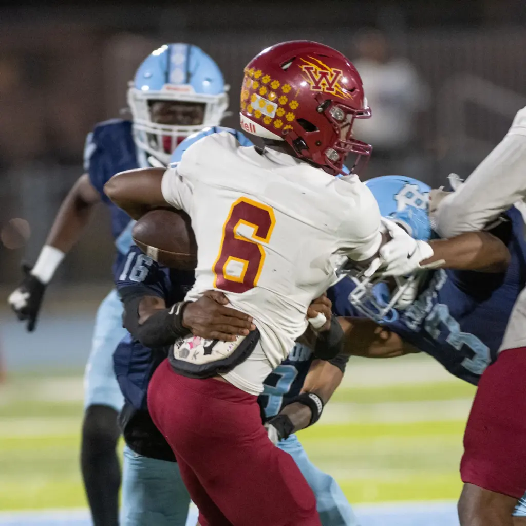 Long Beach Wilson’s Kyle Harris tries to break the tackle...