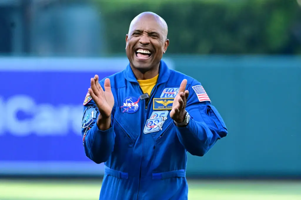Artemis II Astronaut Victor Glover claps after throwing out the...
