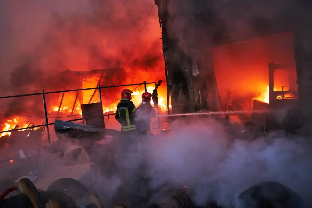 Firefighters try to extinguish a fire following a Russian missile...