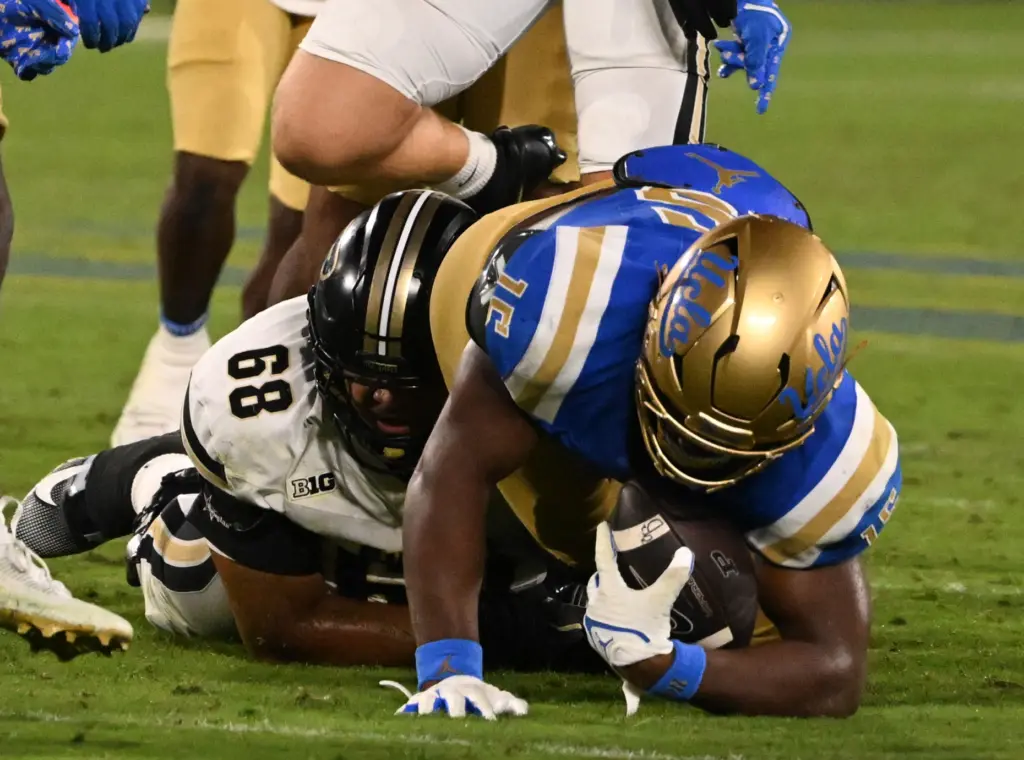 Defensive lineman Sahir West (15) of the UCLA Bruins recovers...