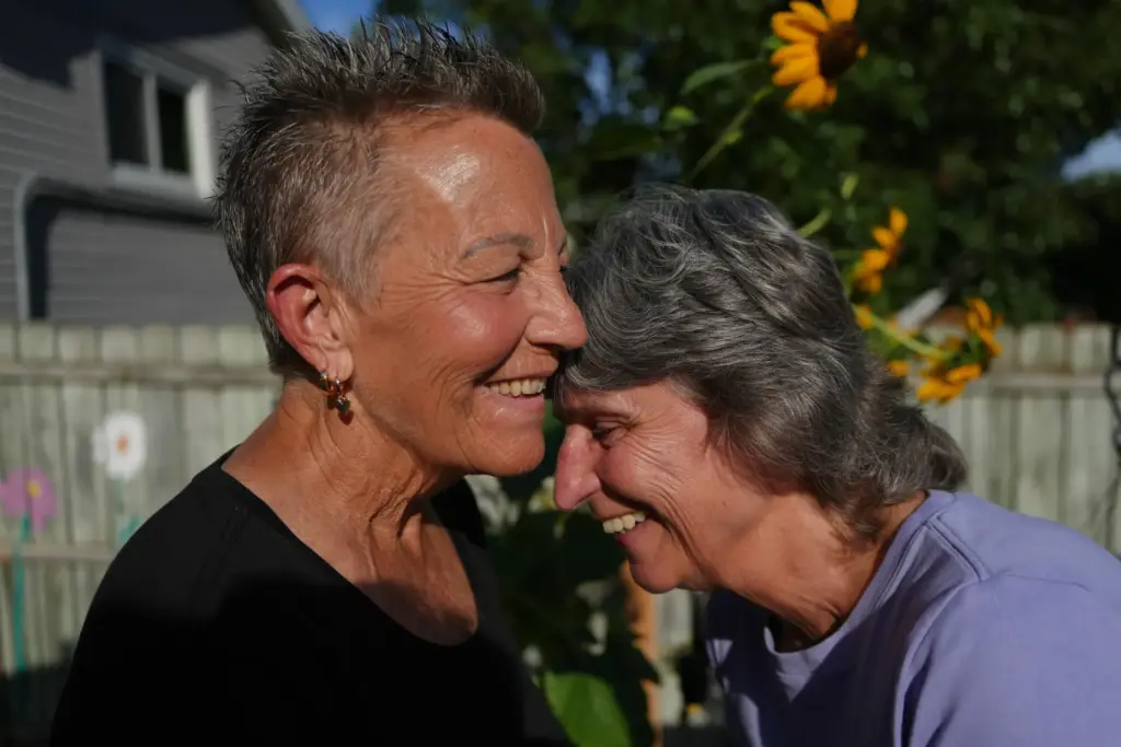 Deb Robertson and her wife, Kate Koubek, laugh in the backyard of their home.