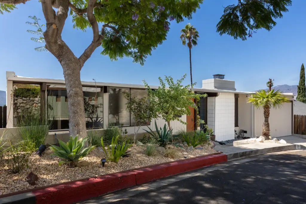 From the curb, the home has a low-slung profile, attached...