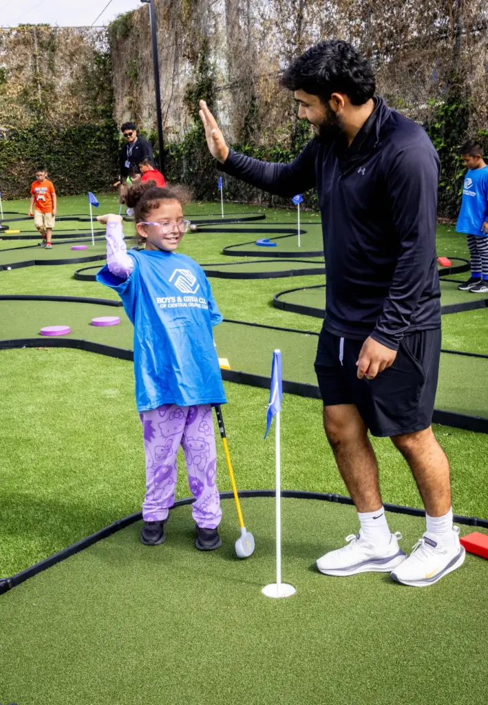 Hannah Cabeda, 9, celebrates a successful golf put with athletic...