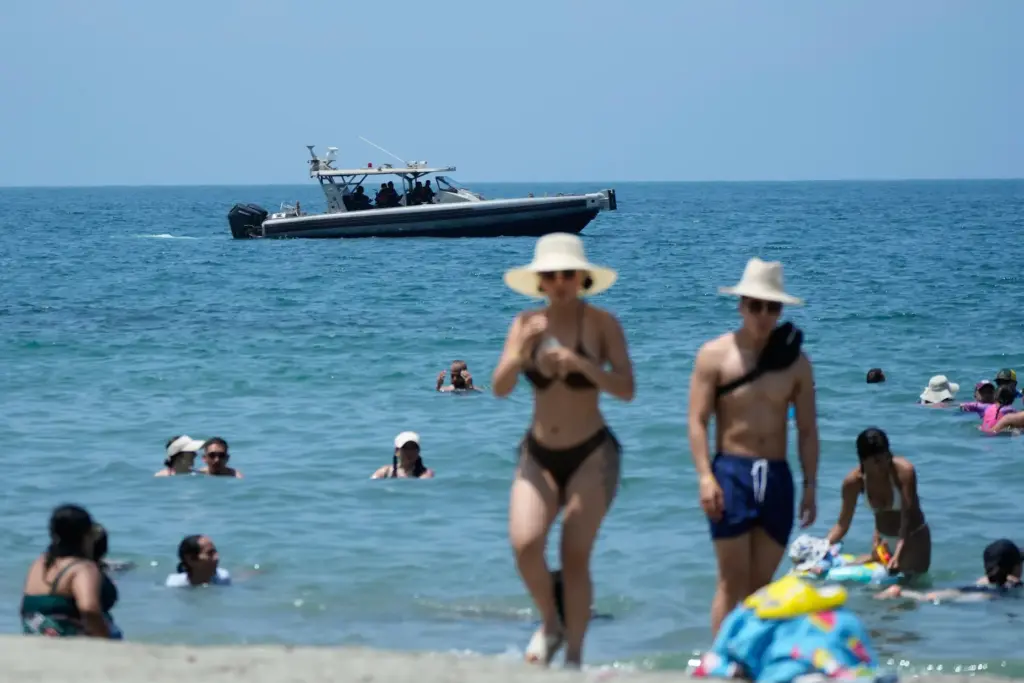 A navy boat patrols off the beach in Santa Marta,...