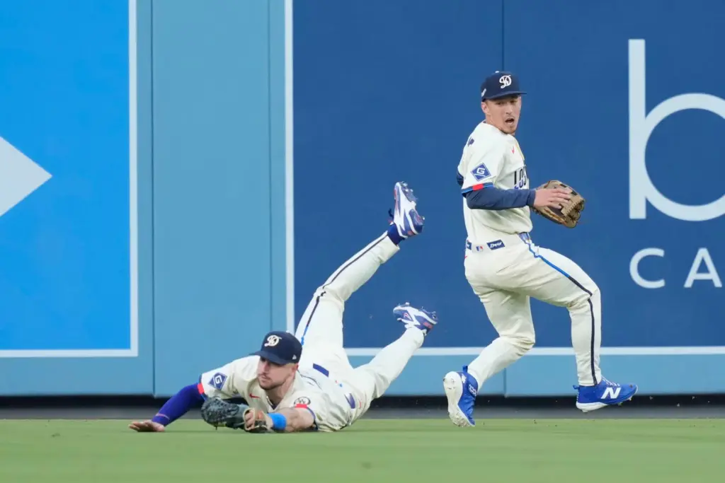 Los Angeles Dodgers right fielder Kyle Tucker, left, makes a...