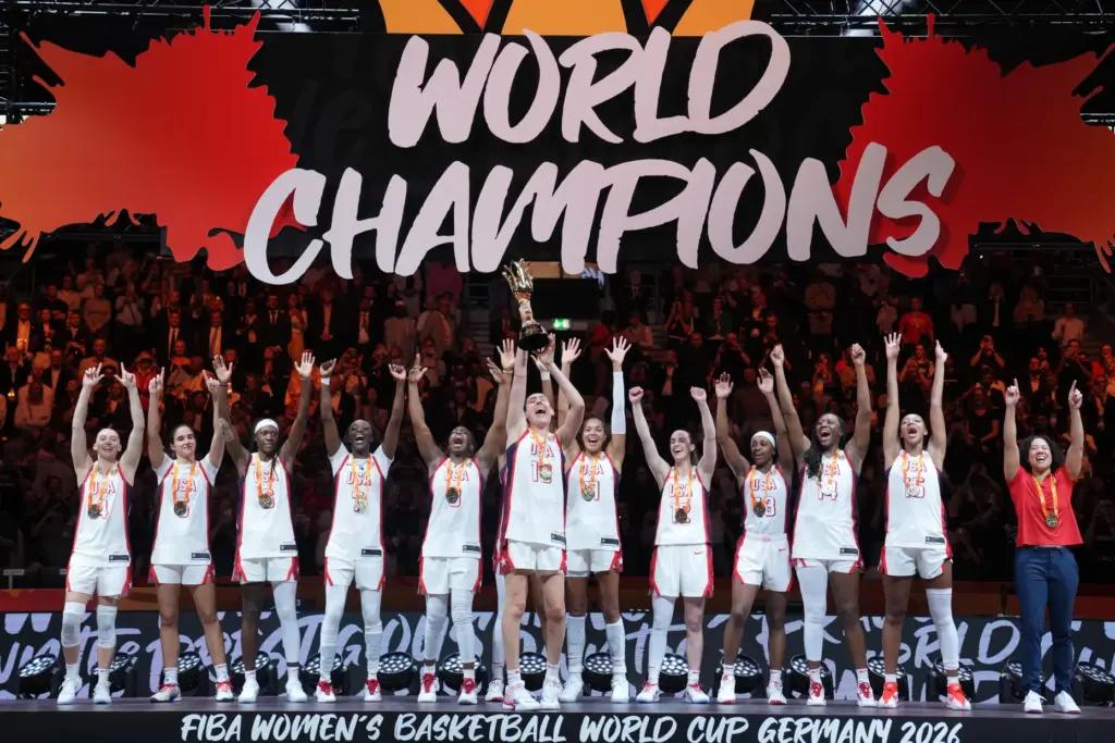 Team USA players and head coach Kara Lawson celebrate on...