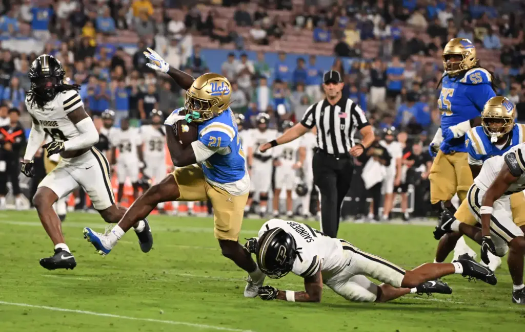 Running back Jaivian Thomas (21) of the UCLA Bruins runs...