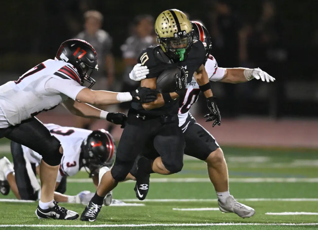Micah Samson #10 of El Dorado runs from Jake Maturo...