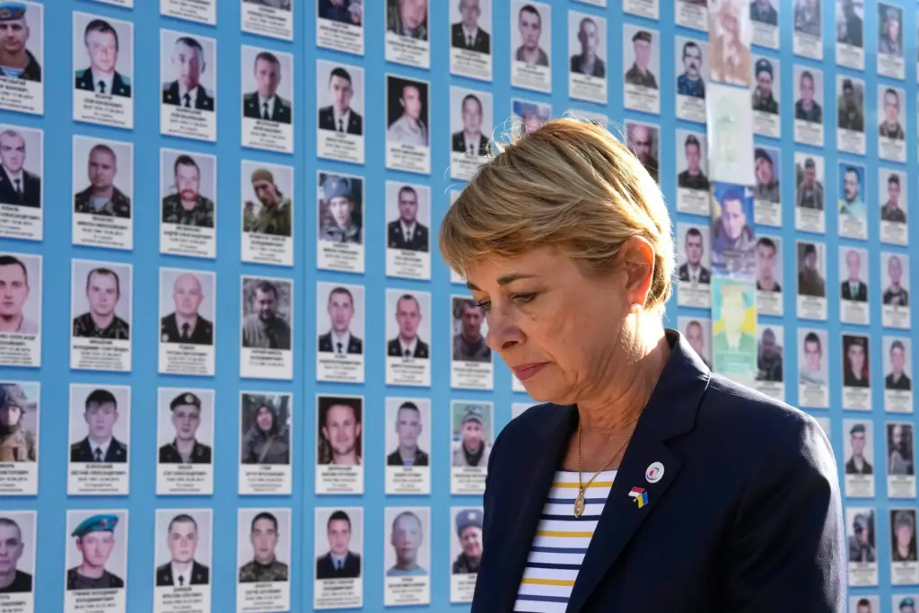 Monaco's Foreign Minister Isabelle Berro-Amadei walks past the Memory Wall of Fallen Defenders of Ukraine.