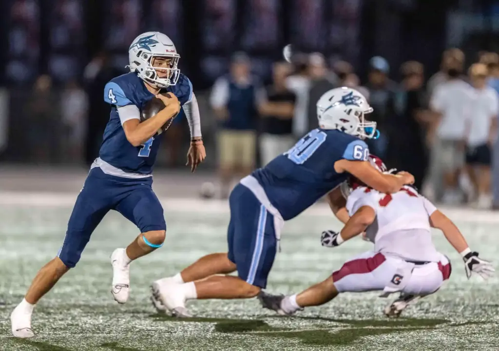 Corona del Mar quarterback John David Annett (4) carries the...