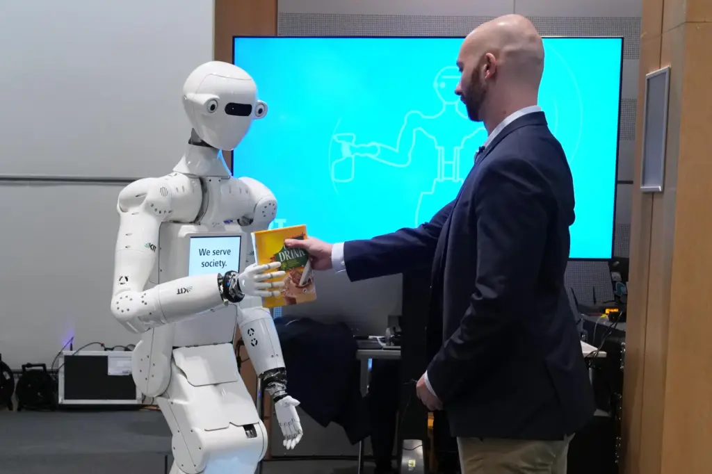 A man receives a box of chocolate powder drink from a robot.