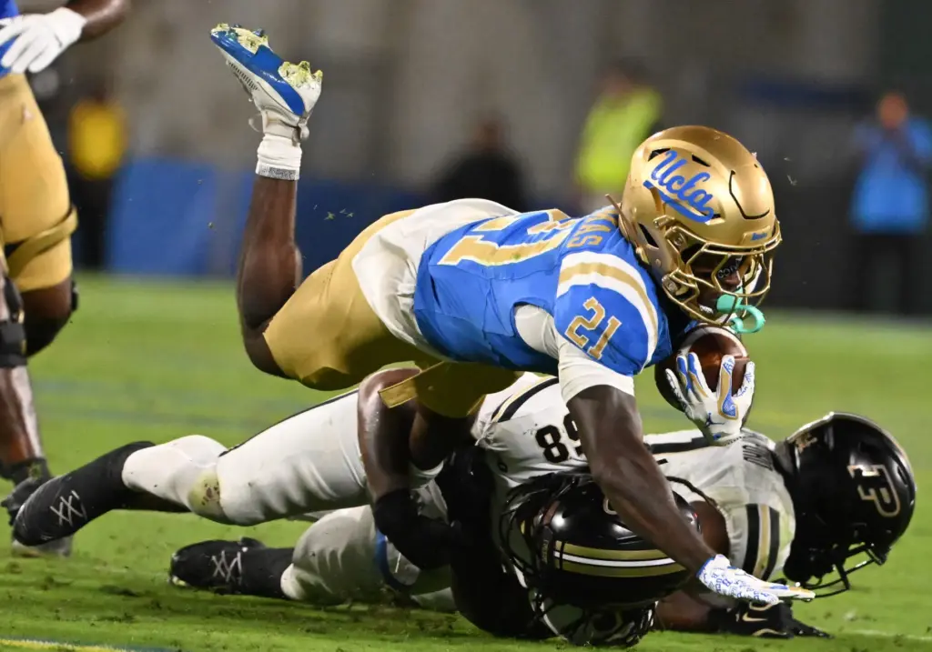 Running back Jaivian Thomas (21) of the UCLA Bruins runs...